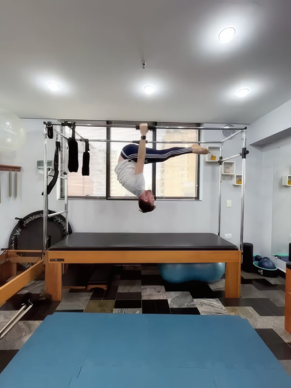 Aluno executando um exercício invertido no Cadillac, no estúdio da Body Movement
